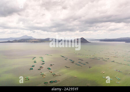 Lake Taal with a volcano and fish cages on a fish farm, top view. Luzon, Philippines Tropical landscape, mountains and volcano in the lake. Stock Photo