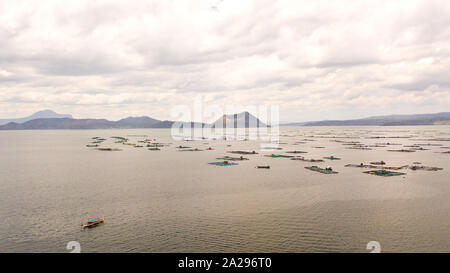 Lake Taal with a volcano and fish cages on a fish farm, top view. Luzon, Philippines Tropical landscape, mountains and volcano in the lake. Stock Photo