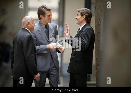 View of three men having a conversation. Stock Photo