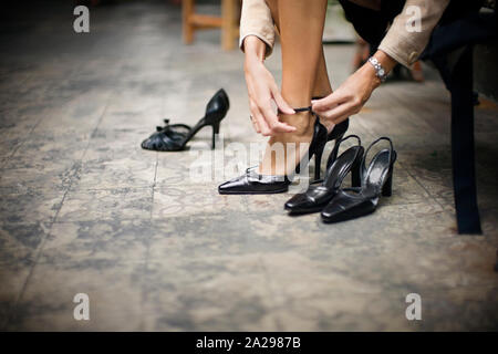 Cropped view of a woman trying on a new pair of sandals. Stock Photo