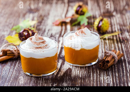 Autumn dessert, pumpkin mousse with whipped cream in glasses Stock Photo