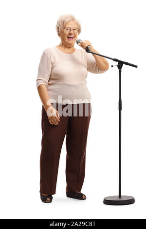 Full length portrait of a cheerful grandmother standing in front of a microphone isolated on white background Stock Photo