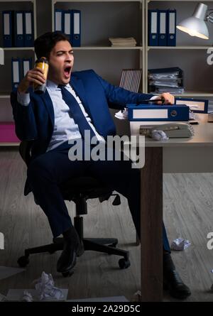 The employee working late and drinking strong coffee to stay awake Stock Photo