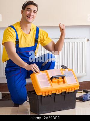 Young repairman contractor repairing heating panel Stock Photo