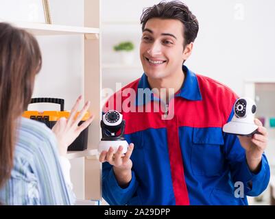 The client getting securty camera installed at home by contractor Stock Photo