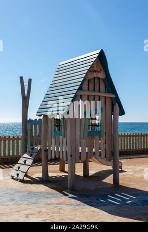 A child's climbing frame and tree house in a playground Stock Photo