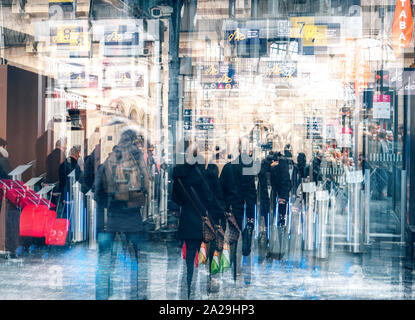 Paris, France - Jan 20, 2019: Qbstrqct defocused co,posite of rear view of crowd of passengers waiting to cross the secure barrier to access the trains on the platform in Gare de Nord Stock Photo