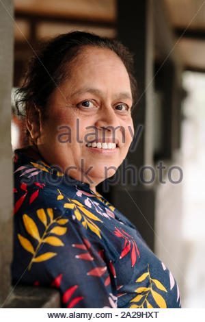 Portrait of a 50s Indian mature woman smiling and looking up having a