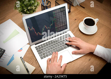 Broker or investor analyzing chart in office. Trading concept with stocks graph on screen. Stock Photo
