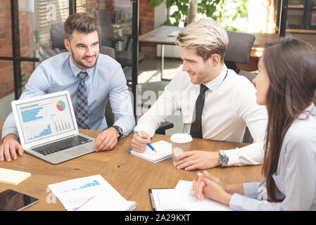 Group of young business people with laptop. Financial and accounting discussion on business meeting Stock Photo