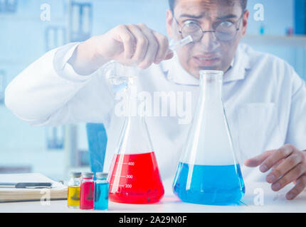 The funny mad chemist working in a laboratory Stock Photo