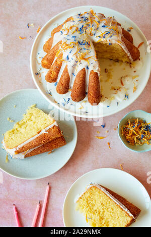 Lemon Drizzle Birthday Cake with Icing and Edible Flowers Stock Photo