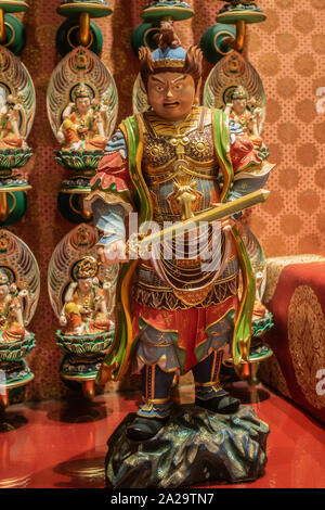 Singapore - March 22, 2019: Buddha Tooth Relic Temple in Chinatown. Virudhaka statue, One of Heavanly Kings, protecting the South with his sword. Colo Stock Photo