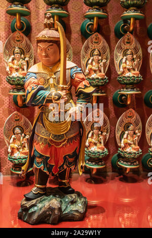 Singapore - March 22, 2019: Buddha Tooth Relic Temple in Chinatown. Fierce looking and colorfully multicolor painted statue of guardian, knight, and p Stock Photo