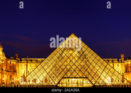 The Louvre and Pyramid illuminated at night Stock Photo