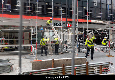 Men working to repair a wall of a HSBC UK bank in Liverpool Stock Photo