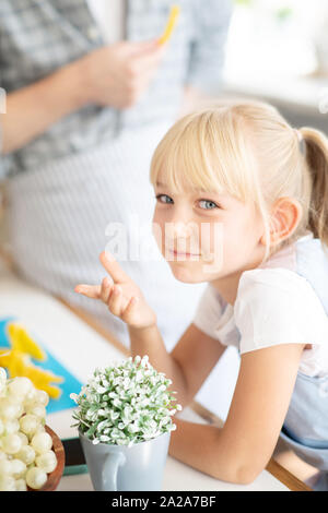 Blue-eyed girl standing near table in the kitchen Stock Photo