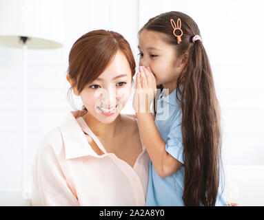 mother and little girl whispering gossip Stock Photo