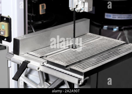 The sharp blade of the band saw is mounted on a modern woodworking machine and provides high precision cutting. Stock Photo