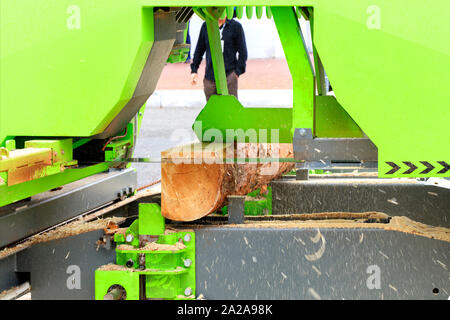 Woodworking, lumber, pine boards are made from large logs in a modern automatic sawmill. Stock Photo
