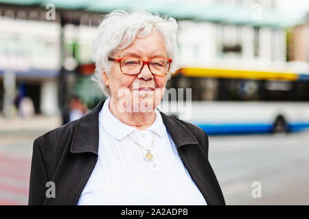 Portrait of senior woman 87 years old on bus station. Travel and active lifestyle concept Stock Photo