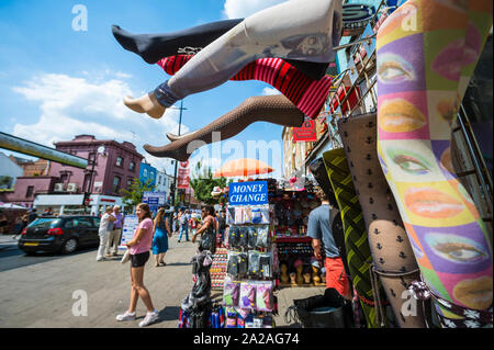 LONDON - JUNE 18, 2017: Visitors browse the funky fashion displayed in the shops lining the High Street of the bohemian neighborhood of Camden Town. Stock Photo