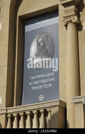 Poster in Serbian Cyrillic advertising Works of Art in the legacy of Nikola Tesla Exhibition on the front facade of the Nikola Tesla Museum, Central Belgrade, Serbia. Stock Photo