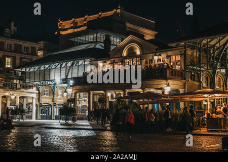 London, United Kingdom - August 31, 2019: People walking front of illuminated Covent Garden Market, one of the most popular tourist sites in London, U Stock Photo