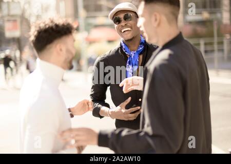 three male friends discussing on street in city Frankfurt, Germany