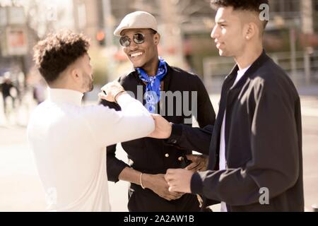 three male friends discussing on street in city Frankfurt, Germany