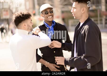 three male friends discussing on street in city Frankfurt, Germany