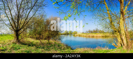 Landschaft im Frühling mit Fluss bei strahlendem Sonnenschein Stock Photo