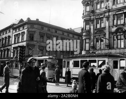 The picture shows a tram in the city center of Cottbus, at a stop. Some people are already waiting there to get on others are just passing by. Stock Photo