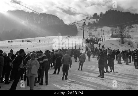 Spectators have lined up along the piste to watch the ski racers during the competition. The Hahnenkamm race has been held on the Hahnenkamm in Kitzbuehel since 1931. Stock Photo