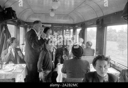 Photo of the interzonal train on the route Leipzig-Gutenfuerst-Hof-Munich. This train was known for its 'all-German' dining car, which was popular due to the 1: 1 exchange rate, especially among East German travelers. View of the crowded dining car of the train. Stock Photo