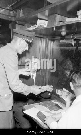 Photo of the interzonal train on the route Leipzig-Gutenfuerst-Hof-Munich. This train was known for its 'all-German' dining car, which was popular due to the 1: 1 exchange rate, especially among East German travelers. Presumably, the uniformed man on the left was a customs official of the GDR, and all popular goods carried by the dining car had to be registered and documented in order to prevent smuggling. Stock Photo