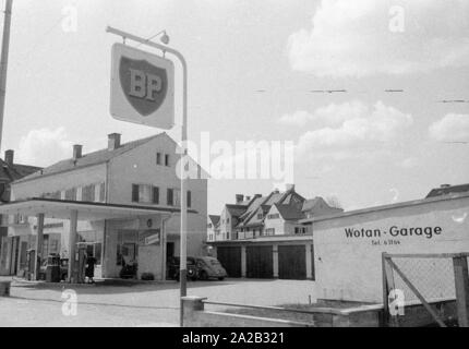 The picture shows a BP gas station in a rural region of Austria, along with some garages. The sign on the flat roof of the gas station and the advertising sign at the entrance show the BP logo from this period. Stock Photo