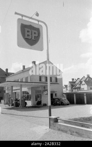 The picture shows a BP gas station in a rural region of Austria, along with some garages. The sign on the flat roof of the gas station and the advertising sign at the entrance show the BP logo from this period. Stock Photo