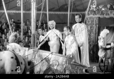 Shooting of the film 'Koenig der Manege' with Rudolf Schock, Germaine Damar and Fritz Imhoff in the main roles. The picture shows the main actors on a horse cart drawn by a horse through the arena. In the center, the main actors Rudolf Schock (elevated) and Germaine Damar. Stock Photo
