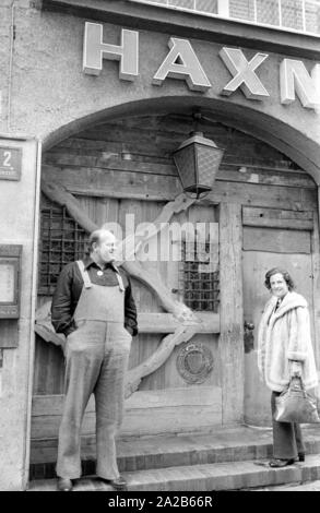 Dan Blocker, who plays the role of Hoss Cartwright in the television series Bonanza, with his wife Dolphia Parker in front of the portal of the restaurant Haxn-Bauer in Munich. Stock Photo