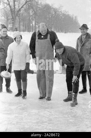 Dan Blocker, who plays the role of Hoss Cartwright in the television series Bonanzna, Bavarian curling on the Nymphenburg Canal. Blocker looks at an ice stock player. Stock Photo