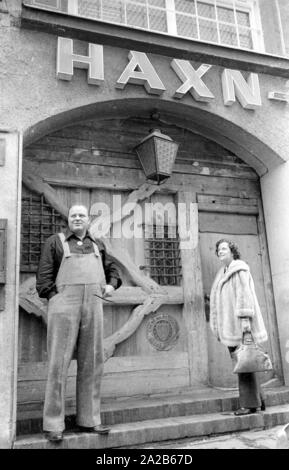 Dan Blocker, who plays the role of Hoss Cartwright in the television series Bonanza, with his wife Dolphia Parker in front of the portal of the restaurant Haxn-Bauer in Munich. Stock Photo