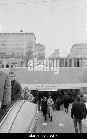 Entrance and exit from the lower level at Stachus, which leads to the S-Bahn and the Stachus shopping center. In the background at left, the department store 'Kaufhof' with advertisements of 'Zechbauer Zigarren' and at right the Hotel Koenigshof (Der Koenigshof). Stock Photo