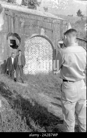 American tourists are photographed by an American GI in front of a bricked up bunker entrance on the Obersalzberg. Stock Photo