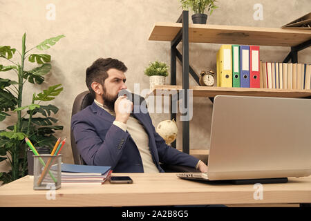 Responding on business e-mail. Brutal businessman in office. Mature man with beard work on laptop. bearded hipster use computer. Male boss working. Keeping business on top with digital technologies. Stock Photo