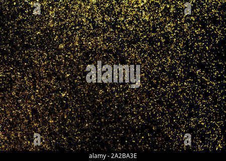 Golden glitter scattered on the black card background, top view, selective focus Stock Photo