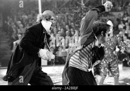 Clowns perform a classic clown act with a funnel in the TV show 'Stars in the Manege' in 1971. Stock Photo