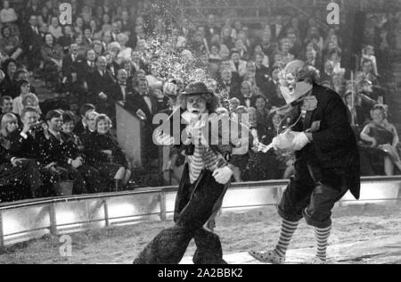 Clowns perform a classic clown act with a funnel in the TV show 'Stars in the Manege' in 1971. Stock Photo