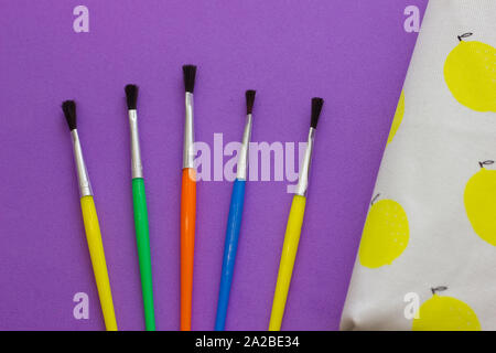 Brushes and pencil case on a violet background. Back to school. View on top Stock Photo
