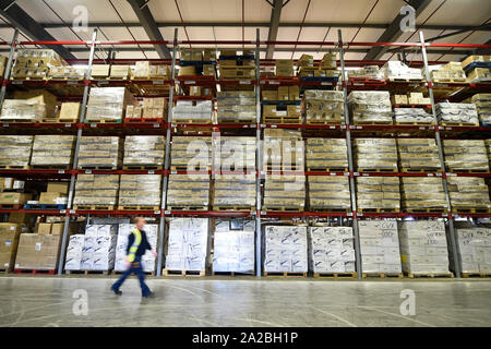 A warehouse worker passes huge racking and pallets of medical supplies, which are being stockpiled as part of Brexit preparations at a NHS Wales warehouse in South Wales. The warehouse is storing extra medical devices and consumables to ensure health and social services continue to run smoothly in the event of a no-deal Brexit. Stock Photo